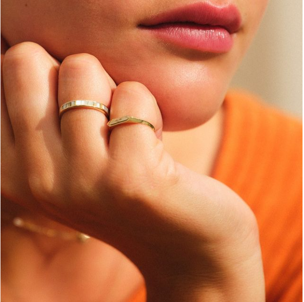 close up image of models hand showing different ring sizes and styles