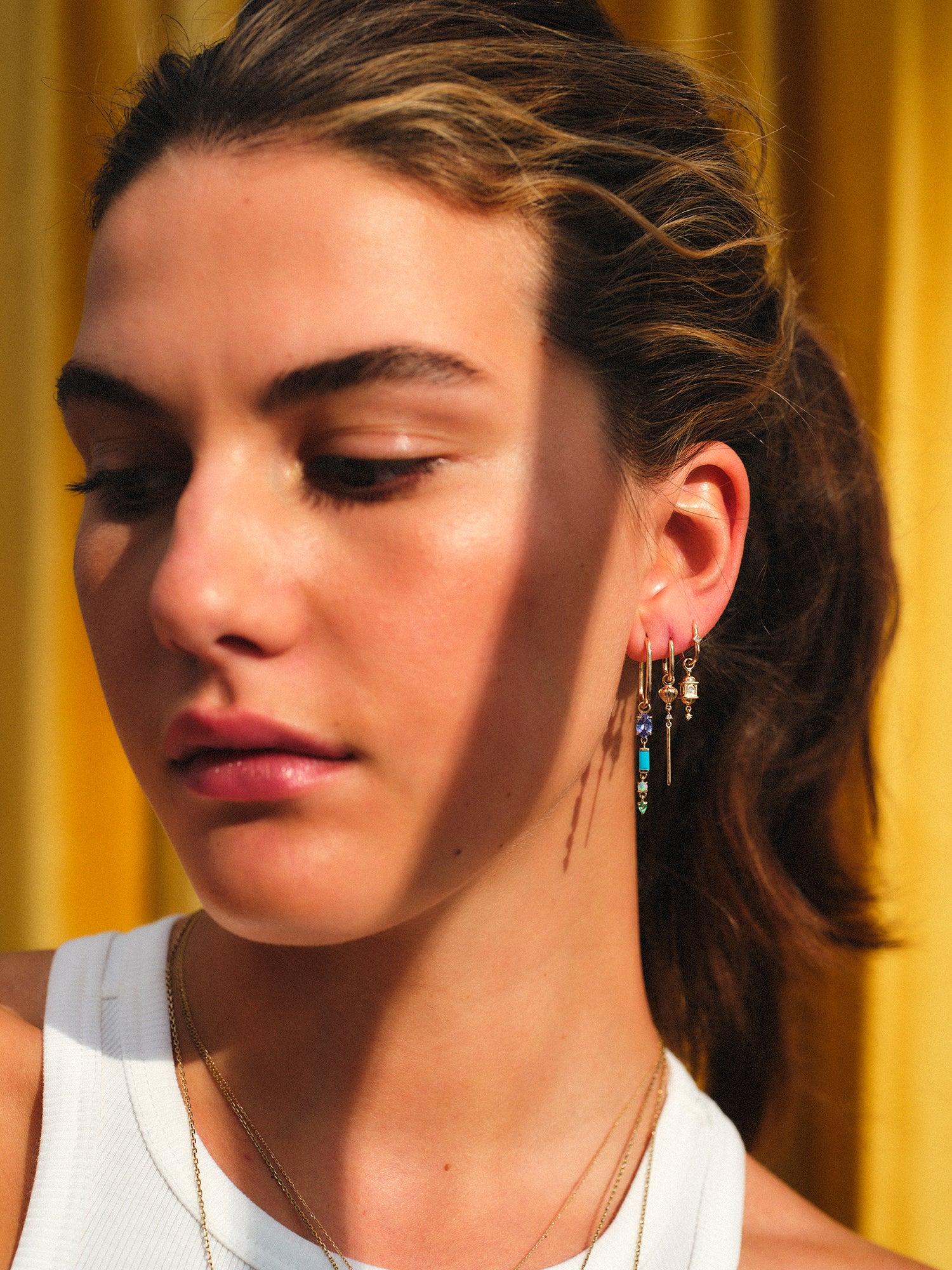 metier model wearing different sized gold earring