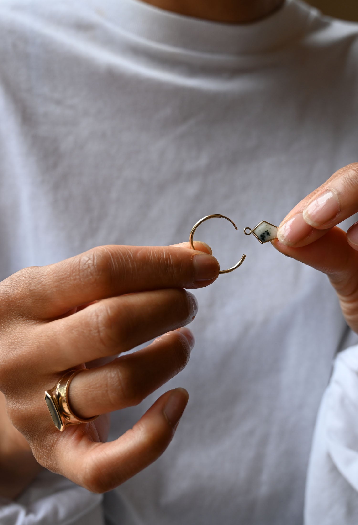 Model adding a plaque to create your own hoop earrings by Metier