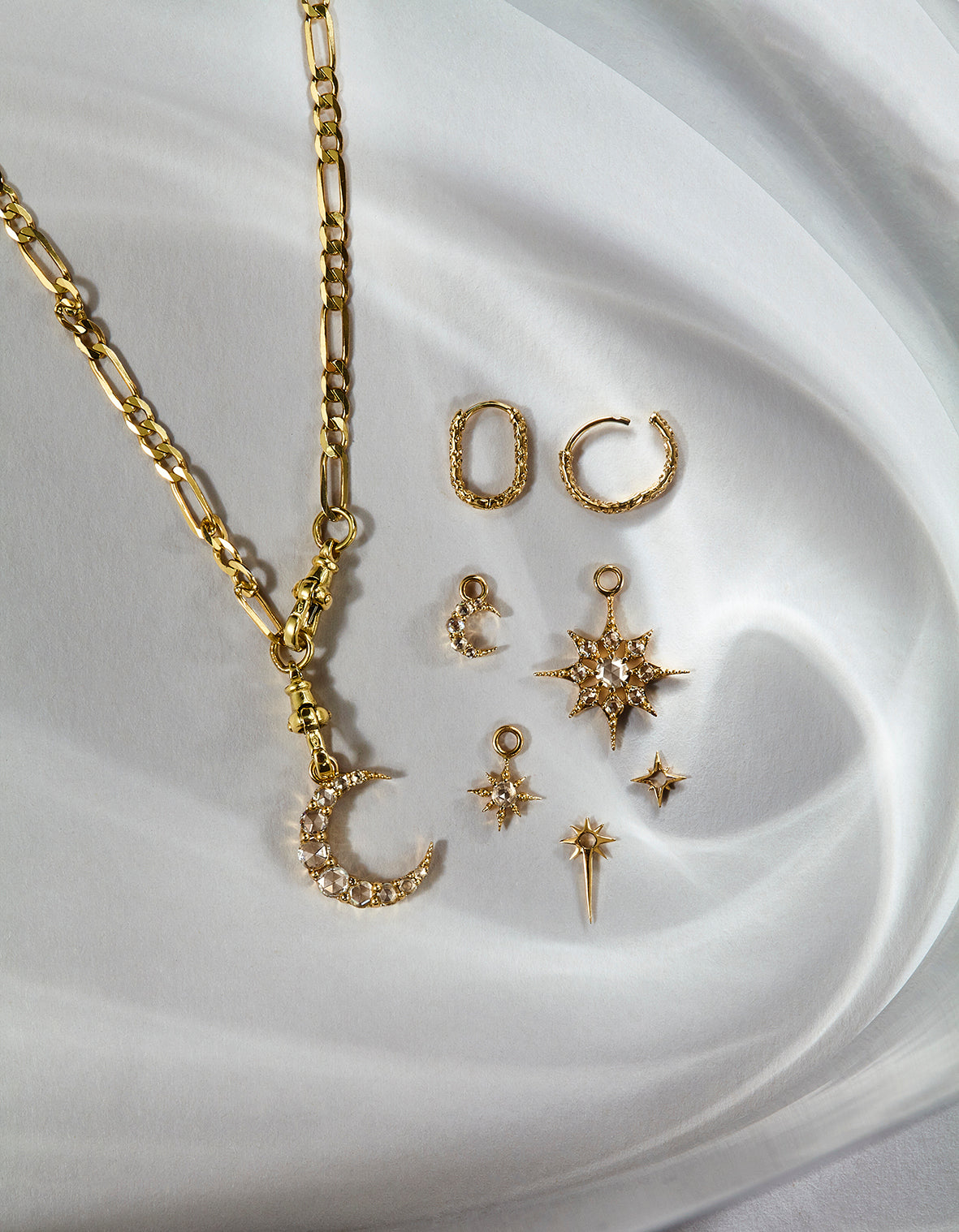 metier by tomfoolery Astra Collection Gold jewelry set including necklace and earrings on a white  background