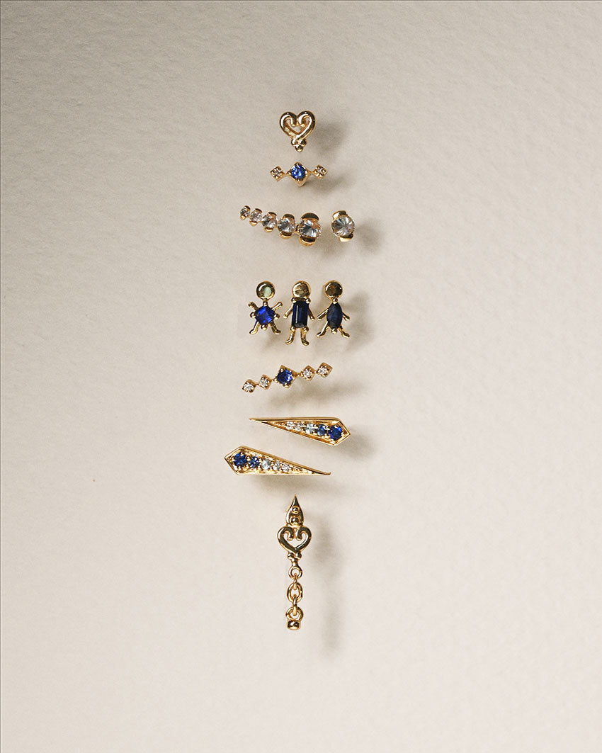Set of gold earrings with gemstones on a beige background 