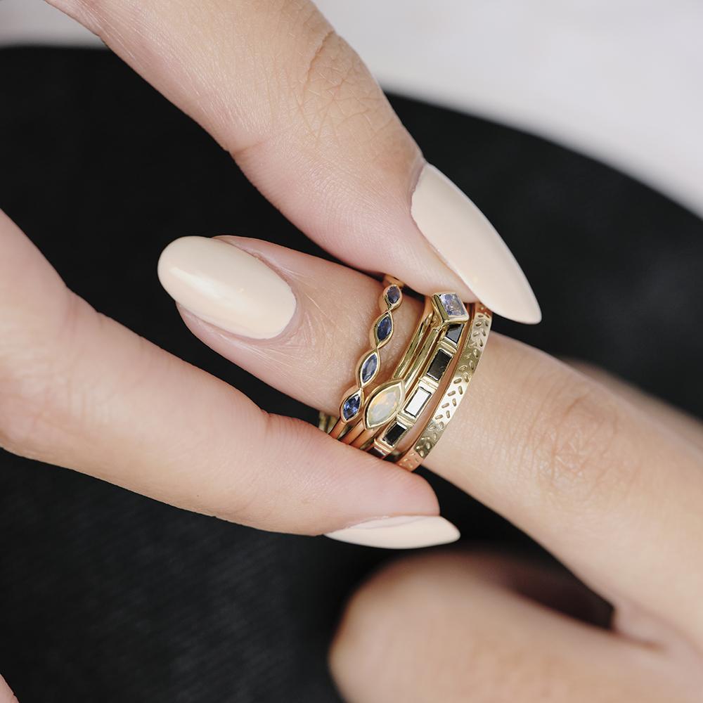 Métier by tomfoolery 5 stone stacking ring in marquise blue sapphires styled with opal stacking ring, dala band and black diamond baguette cut eternity ring.