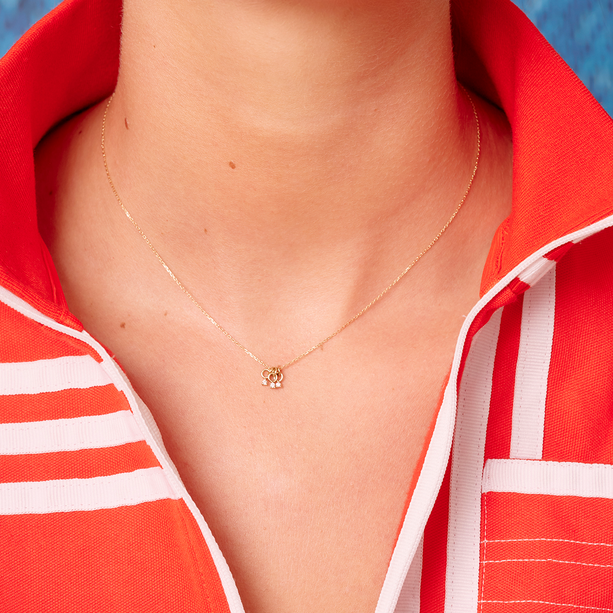 metier by tomfoolery Triple Petite Diamond Pendant shown on model wearing red sports top